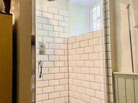 A shower area with tiled walls and a window at the property in 