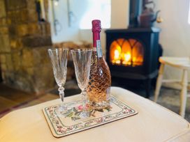 A bottle and glasses on a table with a fireplace in the living room