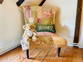 A chair with a quilt and a teddy bear in the sitting room