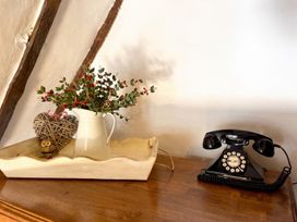 A vase with flowers and a telephone on a table in a living room