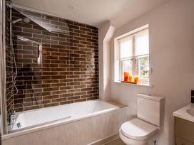 A bathroom featuring a bathtub, shower, toilet and window at the property in 