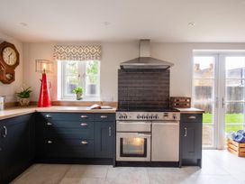 A kitchen with an oven, stove, and clock at 