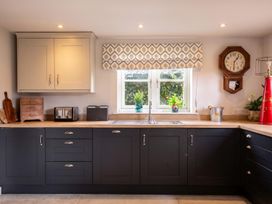 A kitchen with dark cabinets and a sink at The Old Barn in Manchester