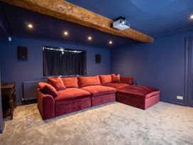 A home theater with a red sofa and projector at the property