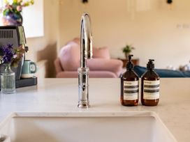 A kitchen with a faucet and soap dispensers at a residence