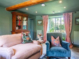 A living room with a sofa and armchair near a window at The Old Barn in Manchester