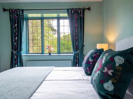 A bedroom with a window and floral decor at The Old Barn in Manchester