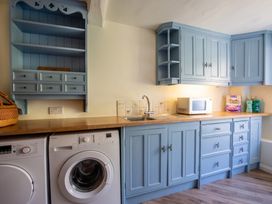 A kitchen with cabinets, a sink, a washing machine, and a microwave at the property in 