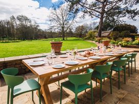 An outdoor dining area with a long table set for a meal at The Old Barn in Manchester
