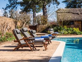 A pool area with sun loungers and towels at a property