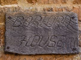 A wooden sign with engraved text at a location named Barford House