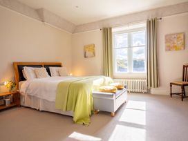 A bedroom with a bed, side table, lamp, and chair at The Old Barn in Manchester