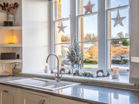 A kitchen with a sink and window showing a winter view at The Old Barn in Manchester