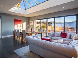 A dining room with a table and chairs by large windows at 