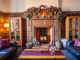 A living room with a fireplace and a wooden table at The Old Barn in Manchester