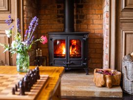 A living room with a wood stove and a chessboard at the property location