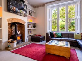 A living room with a fireplace and a television at a property