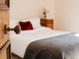 A bedroom with a door handle and a bed at the property location