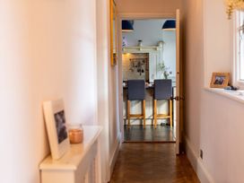 A hallway leading to a kitchen with bar stools at an unknown property in an unknown location