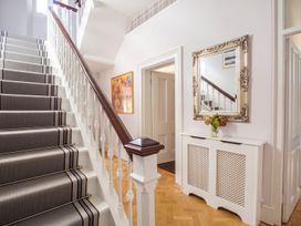 A hallway with a staircase and mirror at The Old Barn in Manchester