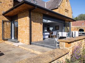 An outdoor patio with seating and a large sliding door at a modern house