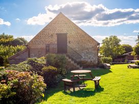 A garden with a stone building and seating area