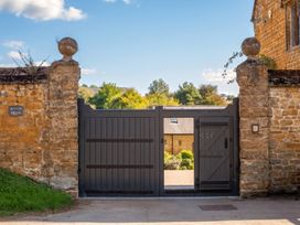 A gate with a stone wall and a sign at Manor House