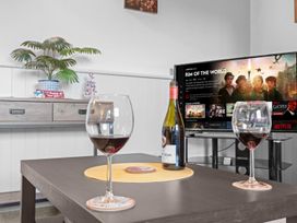A living room with wine glasses and a television displaying Netflix at the property in the unspecified location