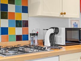 A kitchen with a gas stove and microwave at The Old Barn in Manchester