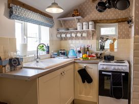A kitchen with sink, stove, and storage jars at The Old Barn in Manchester