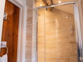A shower with glass doors and a wooden door in a bathroom