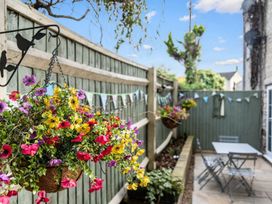A garden with flower baskets and a table with chairs