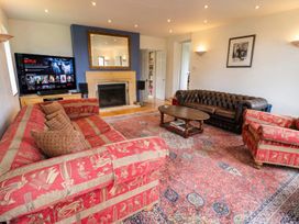 A living room with a sofa and armchair in front of a television at the property