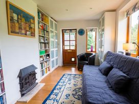 A living room with a bookshelf and armchair at The Old Barn in Manchester
