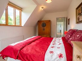 A bedroom with a red bed and wooden wardrobe at The Old Barn in Manchester