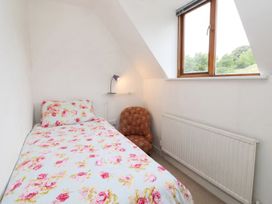 A bedroom with a bed, chair, lamp, radiator and window at 