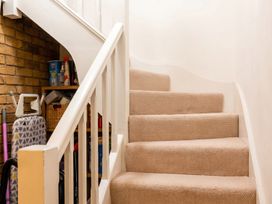 A staircase with a carpet and storage area at The Old Barn in Manchester