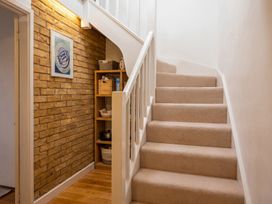 A staircase with a shelf and artwork in a hallway at the property in 
