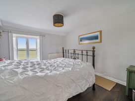 A bedroom with a bed and window at Furzen Farmhouse