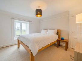 A bedroom with a bed and bedside table at Furzen Farmhouse