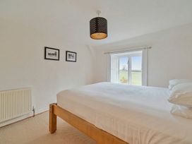 A bedroom with a bed and window at Furzen Farmhouse
