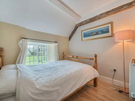 A bedroom with a bed and window at Furzen Farmhouse