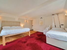 A bedroom with beds and a chair at Furzen Farmhouse