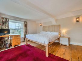 A bedroom with a bed and desk at Furzen Farmhouse