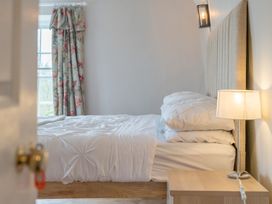 A bedroom with a bed and curtains at Furzen Farmhouse