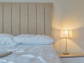 A bedroom with a bed and lamp at Furzen Farmhouse