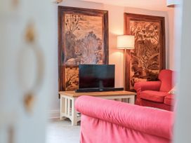 A living room with a sofa and television at Furzen Farmhouse