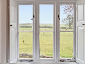 A view of a field with horses from a window at Furzen Farmhouse