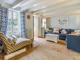 A living room with a sofa and windows at Quay Cottage