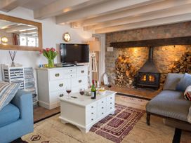A living room with a fireplace and coffee table at Quay Cottage
